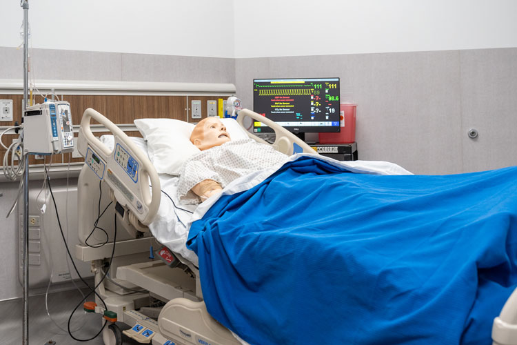 High tech, high-fidelity manikin in hospital bed inside new simulation lab.