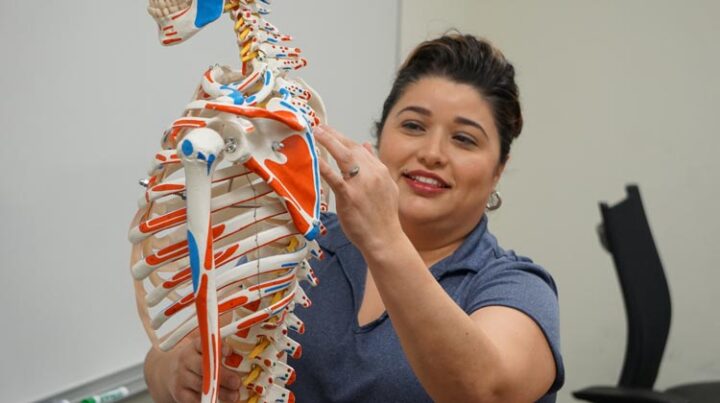 Massage instructor with skeleton prop.