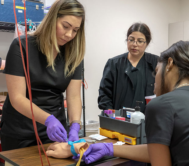 Student practicing drawing blood.