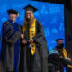 PHOTO: COM President Dr. Helen Brewer (left) poses with a graduate on stage at graduation.